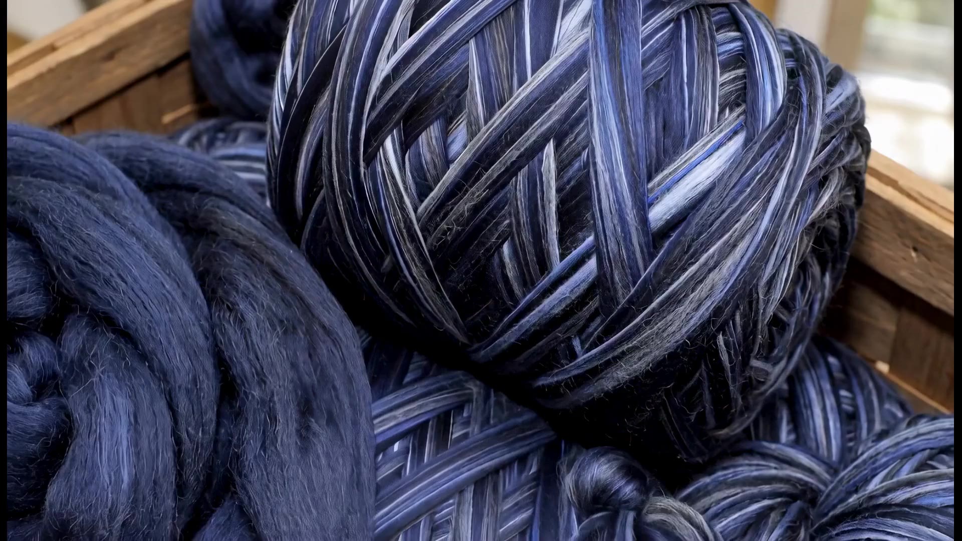 A loom weaving a blue and cream check cloth, seen close at the reed.
