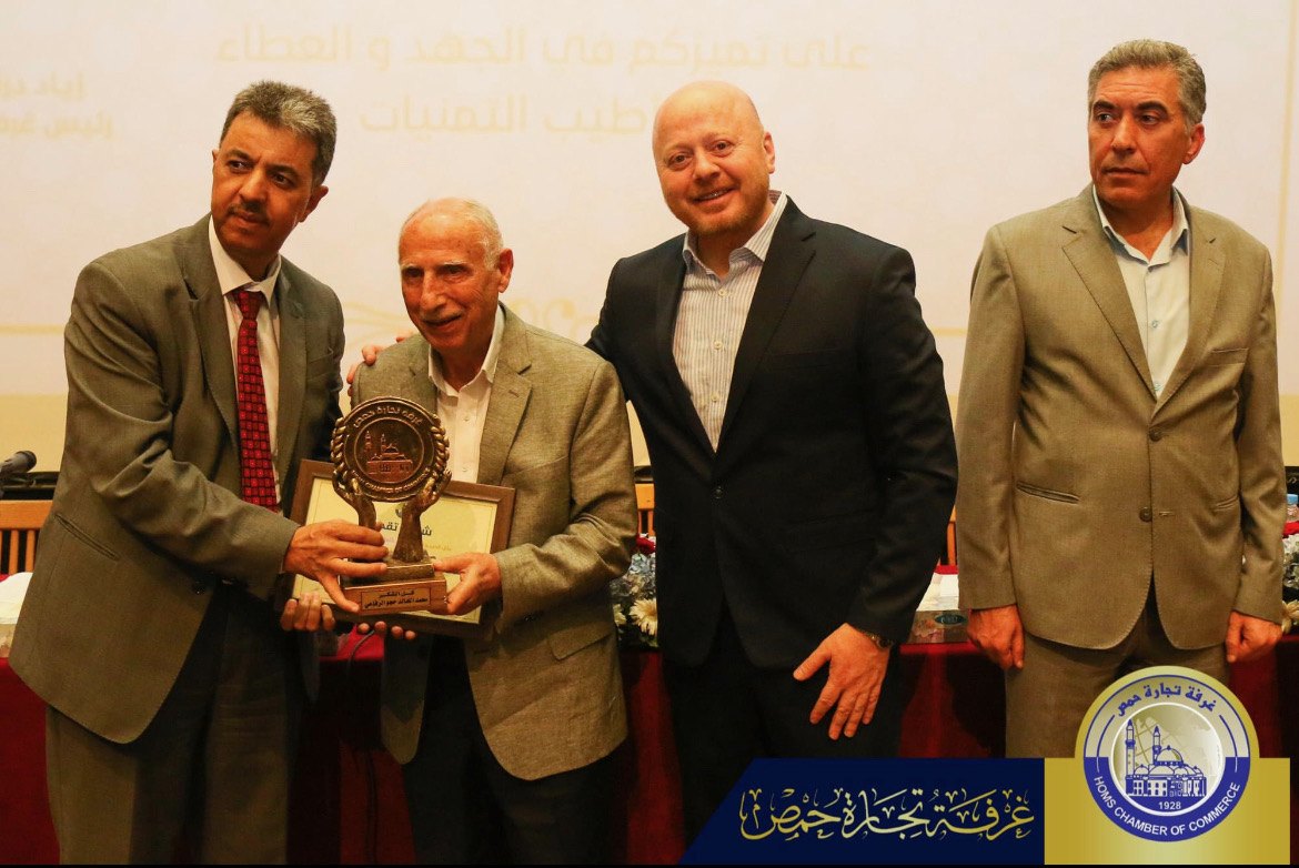 The Chamber of Commerce presents Mohamad Hajjo with an award of honour on stage.