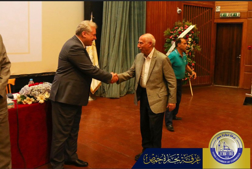 The Governor of Homs shakes hands with Mohamad Hajjo as he presents the award.
